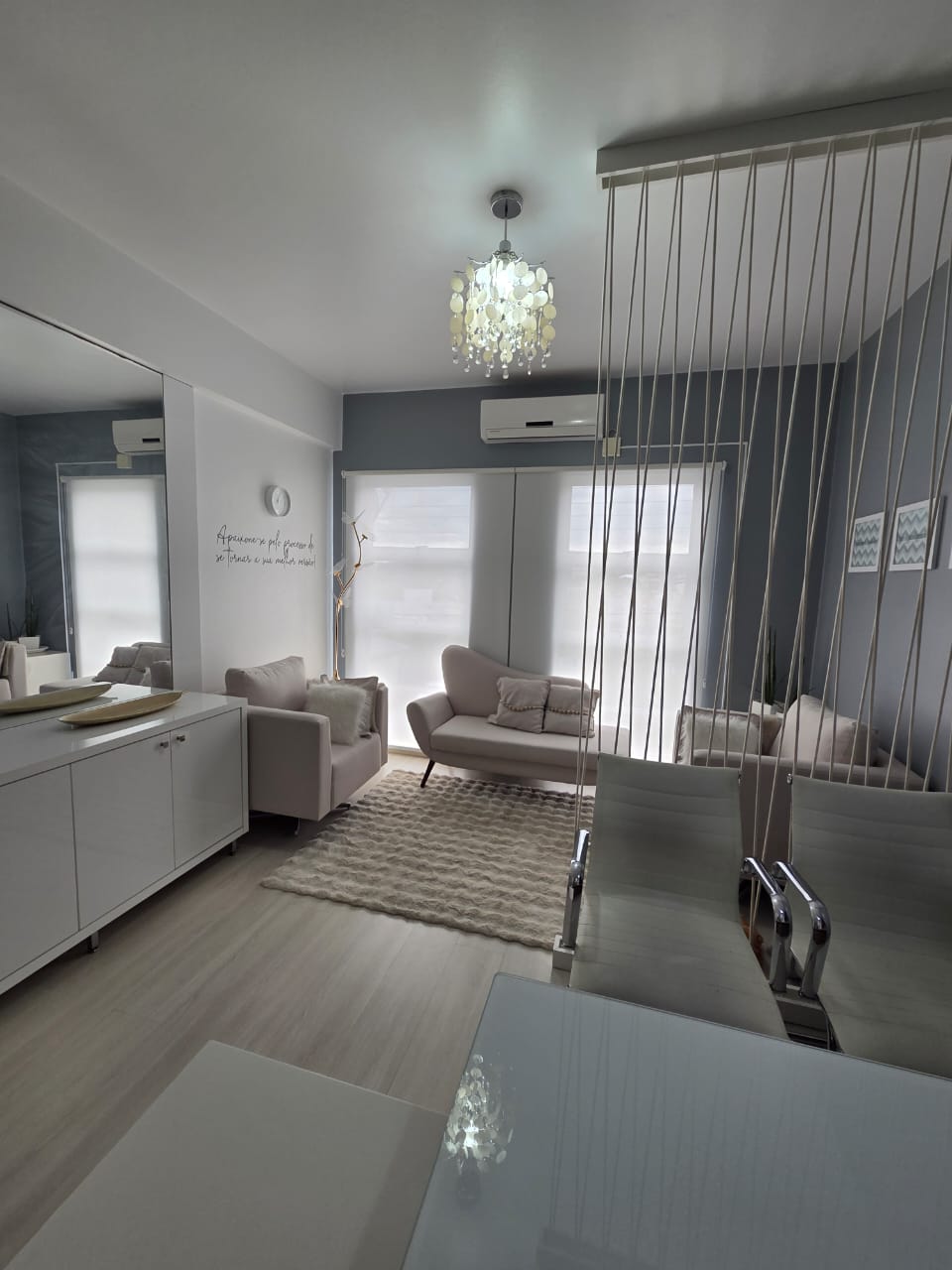 Sala de atendimento adulto com sofá, espelho e ambiente clean em tons de cinza e branco